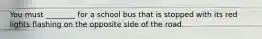 You must ________ for a school bus that is stopped with its red lights flashing on the opposite side of the road.