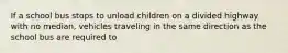 If a school bus stops to unload children on a divided highway with no median, vehicles traveling in the same direction as the school bus are required to