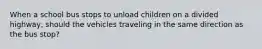 When a school bus stops to unload children on a divided highway, should the vehicles traveling in the same direction as the bus stop?