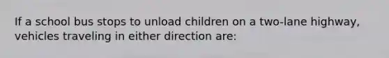 If a school bus stops to unload children on a two-lane highway, vehicles traveling in either direction are: