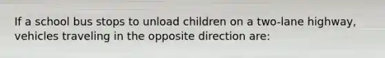 If a school bus stops to unload children on a two-lane highway, vehicles traveling in the opposite direction are: