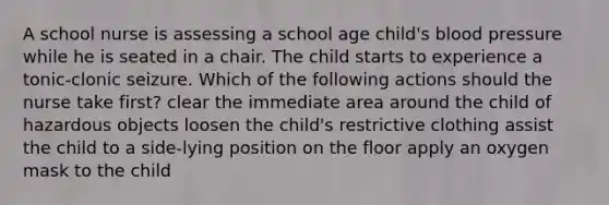 A school nurse is assessing a school age child's blood pressure while he is seated in a chair. The child starts to experience a tonic-clonic seizure. Which of the following actions should the nurse take first? clear the immediate area around the child of hazardous objects loosen the child's restrictive clothing assist the child to a side-lying position on the floor apply an oxygen mask to the child