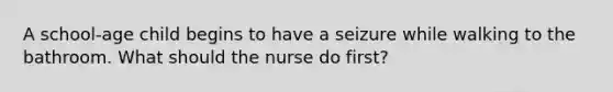 A school-age child begins to have a seizure while walking to the bathroom. What should the nurse do first?