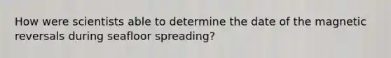How were scientists able to determine the date of the magnetic reversals during seafloor spreading?