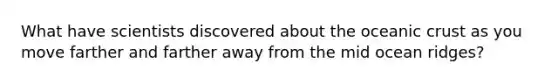 What have scientists discovered about the oceanic crust as you move farther and farther away from the mid ocean ridges?
