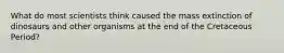 What do most scientists think caused the mass extinction of dinosaurs and other organisms at the end of the Cretaceous Period?