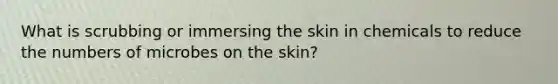 What is scrubbing or immersing the skin in chemicals to reduce the numbers of microbes on the skin?