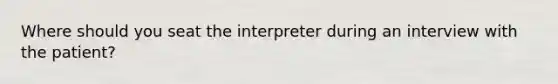 Where should you seat the interpreter during an interview with the patient?