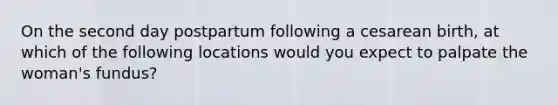 On the second day postpartum following a cesarean birth, at which of the following locations would you expect to palpate the woman's fundus?