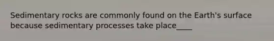 Sedimentary rocks are commonly found on the Earth's surface because sedimentary processes take place____