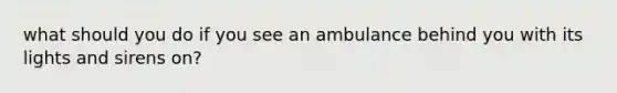 what should you do if you see an ambulance behind you with its lights and sirens on?