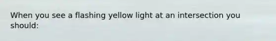 When you see a flashing yellow light at an intersection you should: