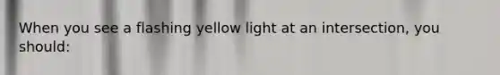 When you see a flashing yellow light at an intersection, you should: