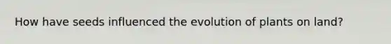How have seeds influenced the evolution of plants on land?