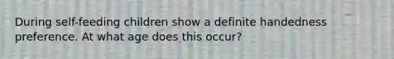 During self-feeding children show a definite handedness preference. At what age does this occur?