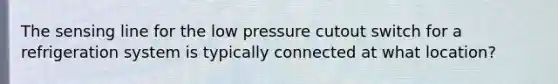 The sensing line for the low pressure cutout switch for a refrigeration system is typically connected at what location?