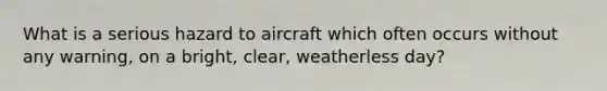 What is a serious hazard to aircraft which often occurs without any warning, on a bright, clear, weatherless day?