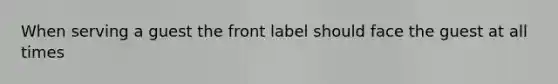 When serving a guest the front label should face the guest at all times