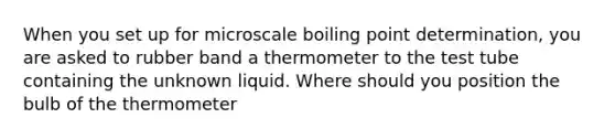 When you set up for microscale boiling point determination, you are asked to rubber band a thermometer to the test tube containing the unknown liquid. Where should you position the bulb of the thermometer