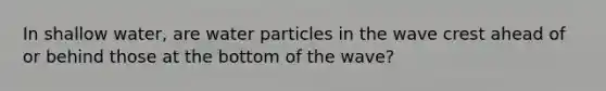 In shallow water, are water particles in the wave crest ahead of or behind those at the bottom of the wave?