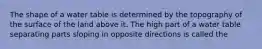 The shape of a water table is determined by the topography of the surface of the land above it. The high part of a water table separating parts sloping in opposite directions is called the