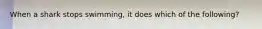 When a shark stops swimming, it does which of the following?