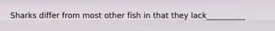 Sharks differ from most other fish in that they lack__________