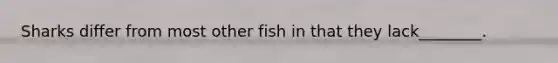 Sharks differ from most other fish in that they lack________.
