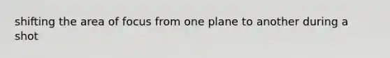 shifting the area of focus from one plane to another during a shot