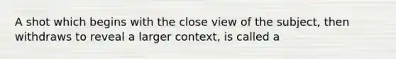 A shot which begins with the close view of the subject, then withdraws to reveal a larger context, is called a