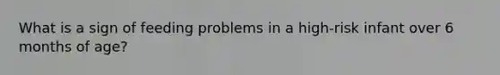 What is a sign of feeding problems in a high-risk infant over 6 months of age?