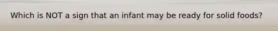 Which is NOT a sign that an infant may be ready for solid foods?