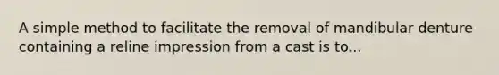 A simple method to facilitate the removal of mandibular denture containing a reline impression from a cast is to...