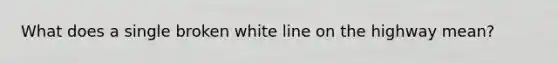 What does a single broken white line on the highway mean?