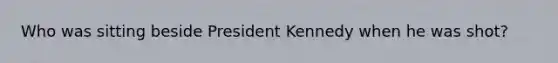 Who was sitting beside President Kennedy when he was shot?