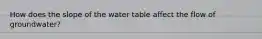 How does the slope of the water table affect the flow of groundwater?