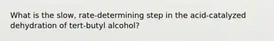 What is the slow, rate-determining step in the acid-catalyzed dehydration of tert-butyl alcohol?