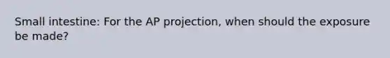 Small intestine: For the AP projection, when should the exposure be made?