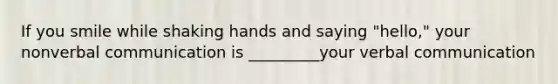 If you smile while shaking hands and saying "hello," your nonverbal communication is _________your verbal communication