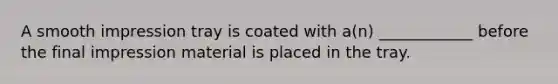 A smooth impression tray is coated with a(n) ____________ before the final impression material is placed in the tray.