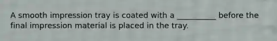 A smooth impression tray is coated with a __________ before the final impression material is placed in the tray.
