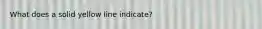 What does a solid yellow line indicate?