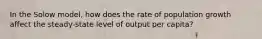 In the Solow model, how does the rate of population growth affect the steady-state level of output per capita?