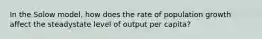 In the Solow model, how does the rate of population growth affect the steadystate level of output per capita?