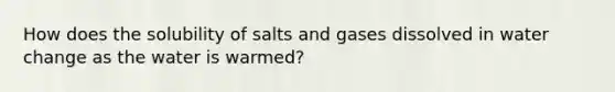 How does the solubility of salts and gases dissolved in water change as the water is warmed?