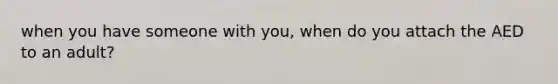 when you have someone with you, when do you attach the AED to an adult?