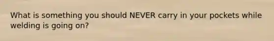What is something you should NEVER carry in your pockets while welding is going on?