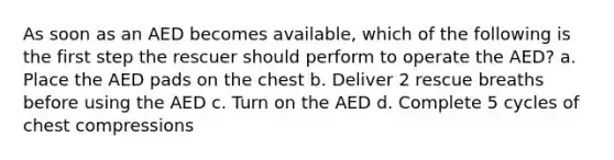 As soon as an AED becomes available, which of the following is the first step the rescuer should perform to operate the AED? a. Place the AED pads on the chest b. Deliver 2 rescue breaths before using the AED c. Turn on the AED d. Complete 5 cycles of chest compressions