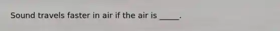 Sound travels faster in air if the air is _____.