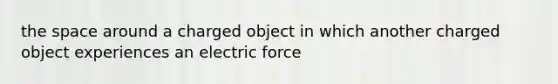 the space around a charged object in which another charged object experiences an electric force